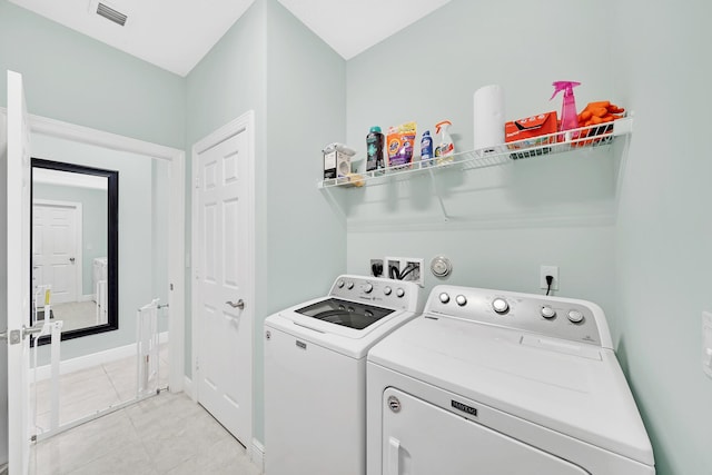 washroom featuring light tile patterned floors and washer and clothes dryer