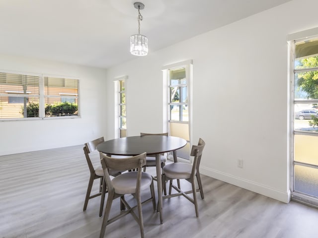 dining room featuring light wood-style flooring and baseboards