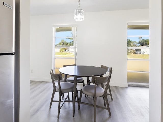 dining area featuring wood finished floors, baseboards, and plenty of natural light