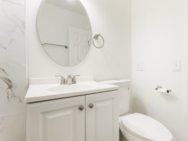 half bathroom featuring toilet and vanity