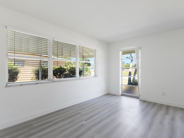 unfurnished room featuring baseboards and wood finished floors