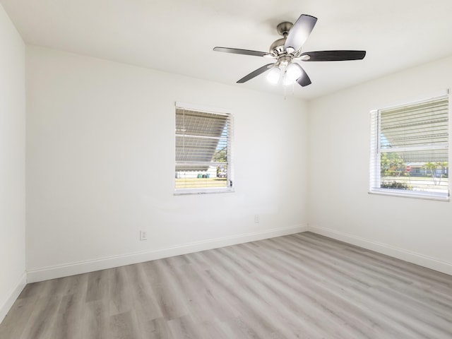 unfurnished room with ceiling fan, baseboards, a healthy amount of sunlight, and light wood-type flooring