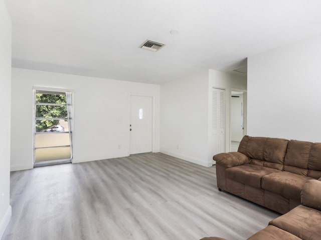 living area featuring visible vents, baseboards, and light wood-style floors