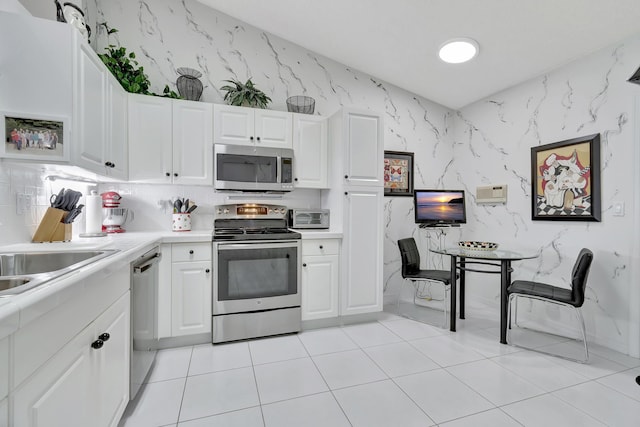 kitchen with white cabinetry, light tile patterned floors, and stainless steel appliances