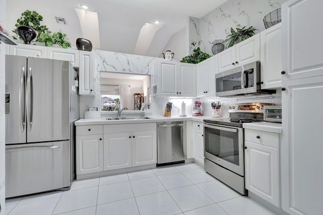 kitchen with light tile patterned flooring, stainless steel appliances, sink, and white cabinets