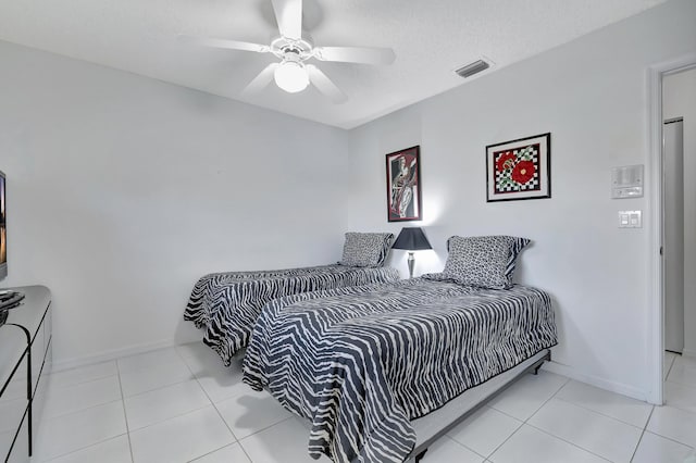 tiled bedroom with a textured ceiling and ceiling fan