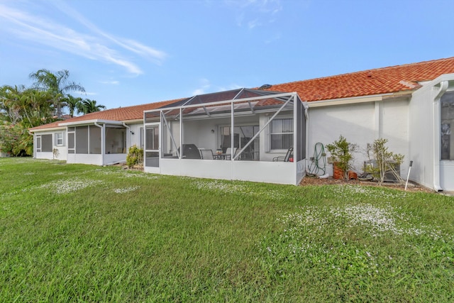 back of property featuring a yard and glass enclosure