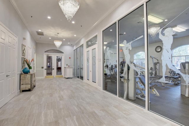 corridor with french doors, crown molding, and an inviting chandelier