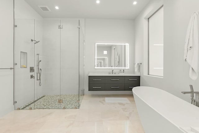 bathroom with independent shower and bath, vanity, and a wealth of natural light