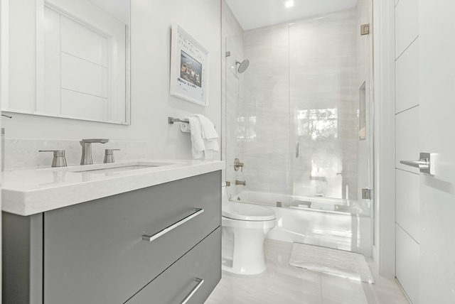 full bathroom featuring enclosed tub / shower combo, vanity, and toilet