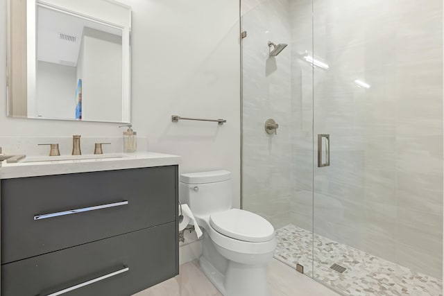 bathroom featuring vanity, a shower with shower door, and toilet