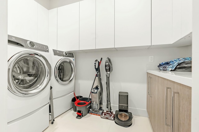 laundry room featuring independent washer and dryer and cabinets