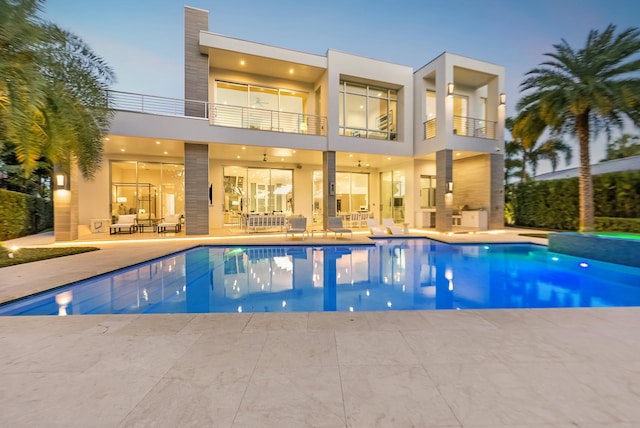 pool at dusk featuring a patio area