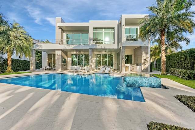 back of house featuring a balcony and a patio area