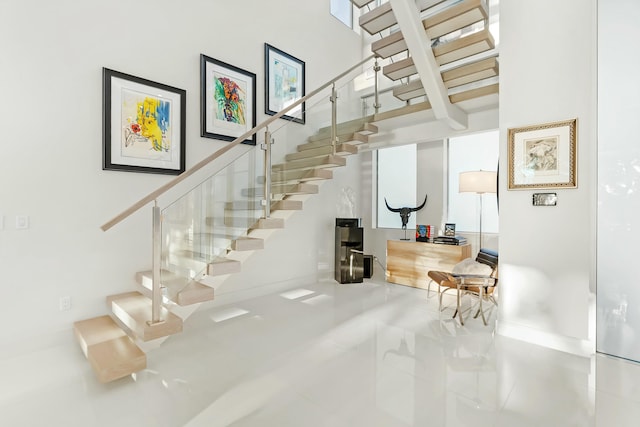 stairs featuring a high ceiling and tile patterned flooring