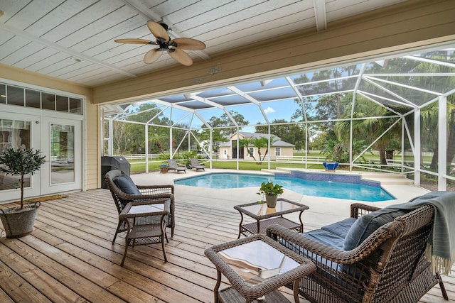 outdoor pool featuring a lanai, ceiling fan, and a deck