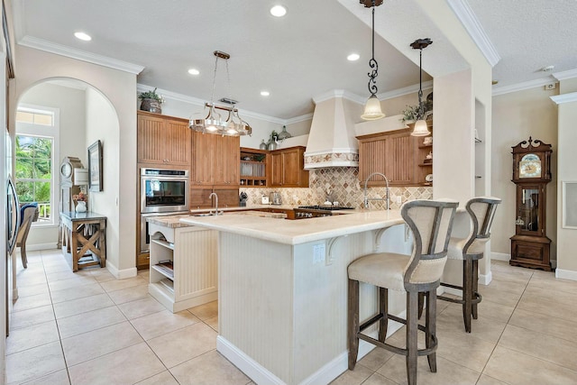 kitchen featuring light tile patterned floors, wall chimney exhaust hood, light countertops, double oven, and open shelves