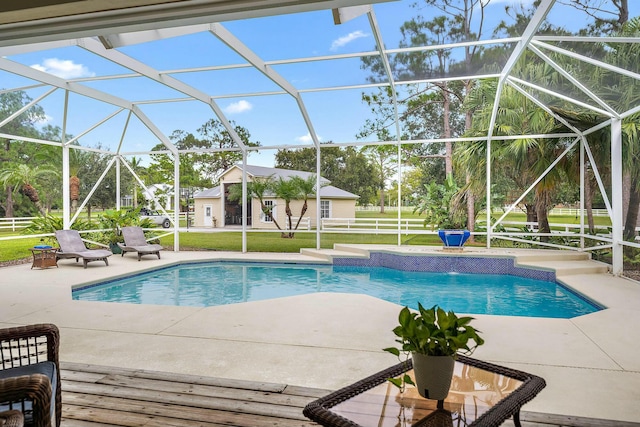 pool featuring glass enclosure, a patio, and a lawn
