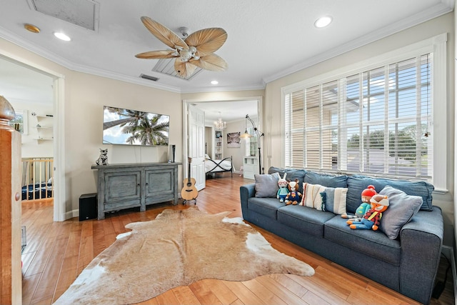 living room with wood finished floors, visible vents, and crown molding