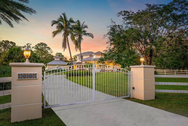 view of gate featuring a yard and fence