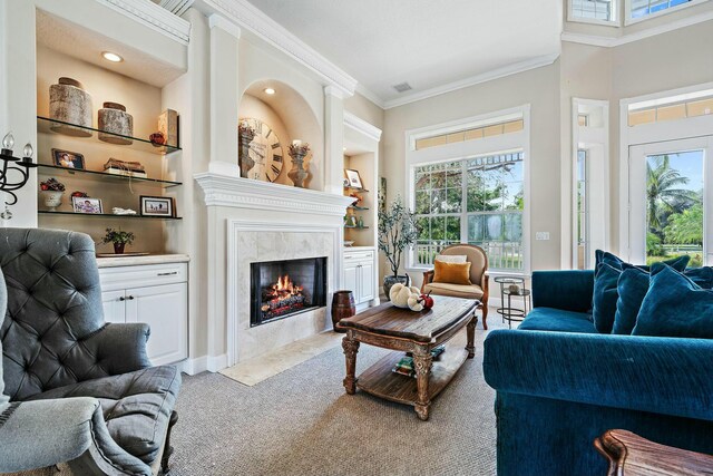 living room with baseboards, built in features, ornamental molding, carpet floors, and a high end fireplace