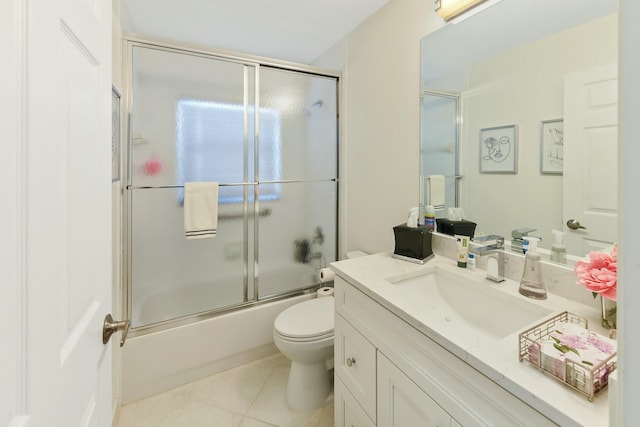 full bathroom featuring vanity, bath / shower combo with glass door, tile patterned floors, and toilet