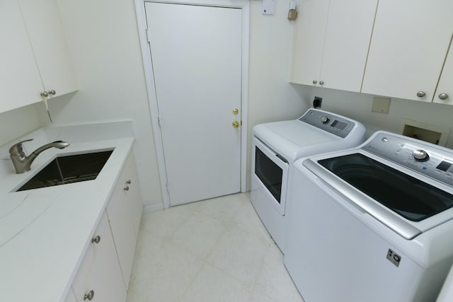 clothes washing area featuring sink, light tile patterned floors, cabinets, and washing machine and clothes dryer