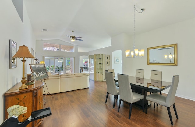 dining space with high vaulted ceiling, ceiling fan with notable chandelier, and dark hardwood / wood-style flooring