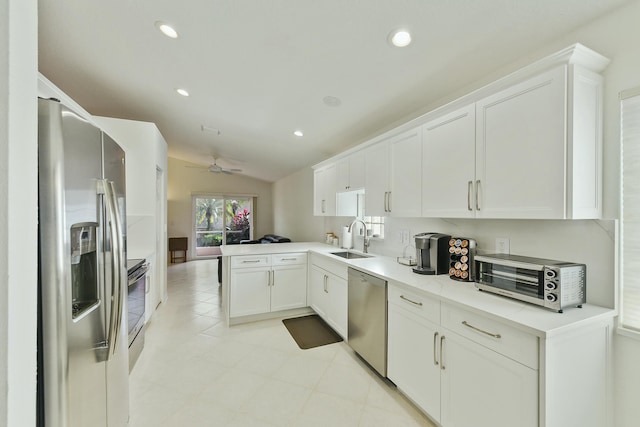 kitchen featuring sink, plenty of natural light, kitchen peninsula, stainless steel appliances, and white cabinets