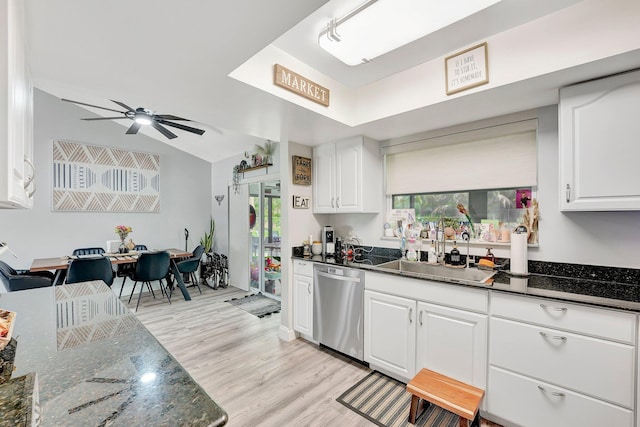 kitchen with white cabinetry, stainless steel dishwasher, and dark stone counters