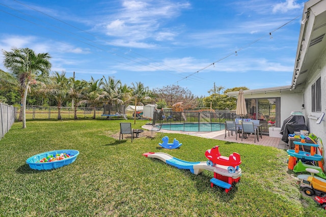 view of yard with a fenced in pool, a patio area, and a trampoline