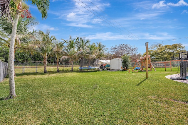 view of yard with a trampoline, a storage shed, and a playground