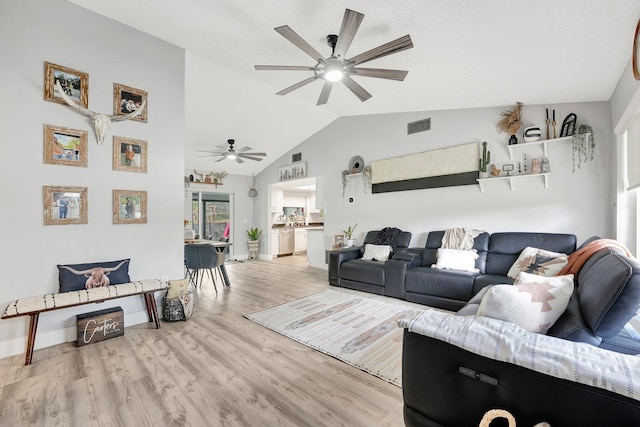 living room featuring lofted ceiling, light hardwood / wood-style floors, and ceiling fan