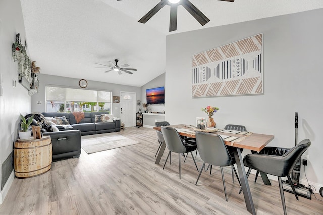 dining space with lofted ceiling, a textured ceiling, ceiling fan, and light hardwood / wood-style flooring