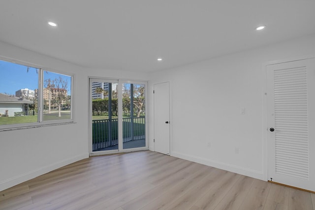 spare room with light wood-style floors, recessed lighting, and baseboards