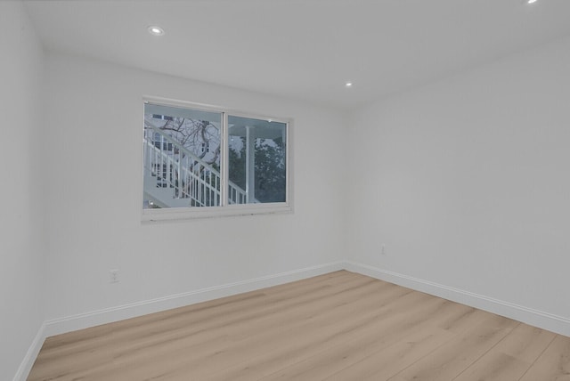 unfurnished room featuring recessed lighting, light wood-style flooring, and baseboards