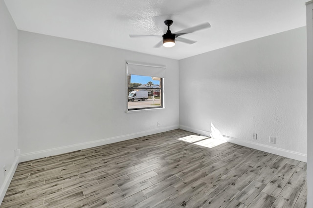 spare room with ceiling fan, light hardwood / wood-style flooring, and a textured ceiling