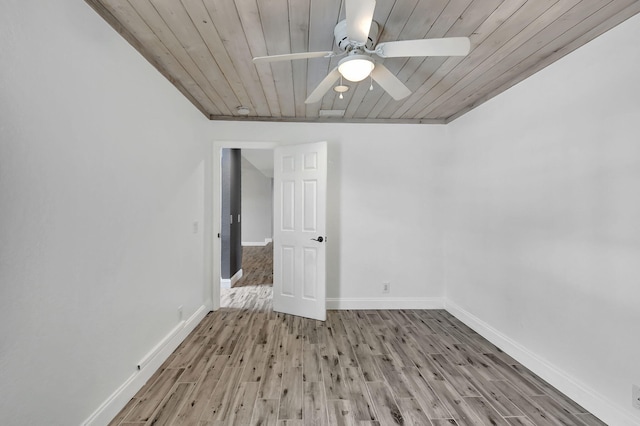 spare room with ceiling fan, wooden ceiling, and light wood-type flooring