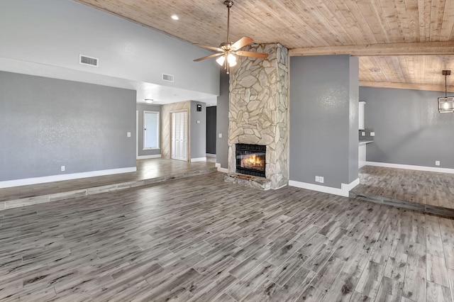 unfurnished living room featuring wood ceiling, a stone fireplace, wood-type flooring, and ceiling fan