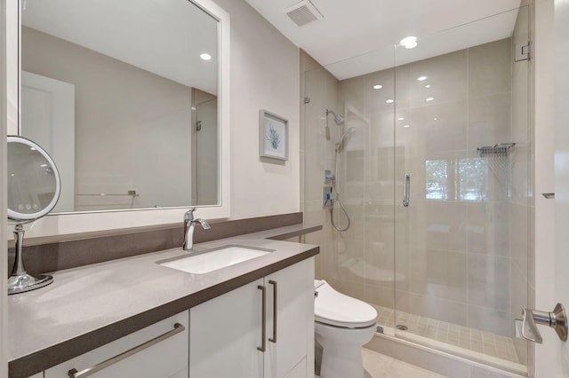 bathroom featuring vanity, an enclosed shower, and toilet