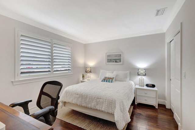 bedroom featuring dark wood-type flooring, ornamental molding, and a closet