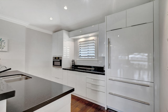 kitchen with white cabinetry, sink, stainless steel oven, and crown molding