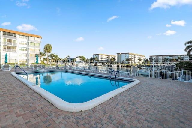 view of pool with a patio area and a water view