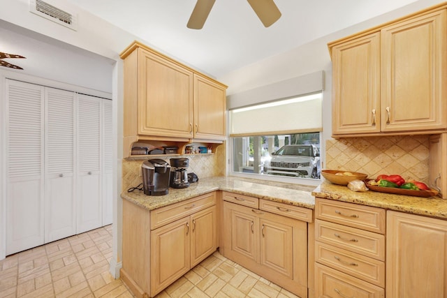 kitchen with tasteful backsplash, light brown cabinetry, and light stone countertops