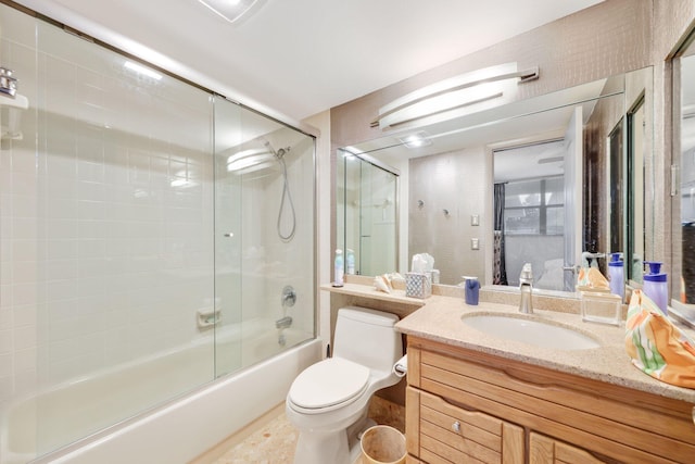 full bathroom featuring shower / bath combination with glass door, vanity, and toilet