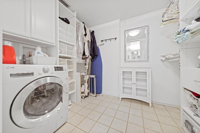 laundry room with cabinets, washer / clothes dryer, and light tile patterned floors