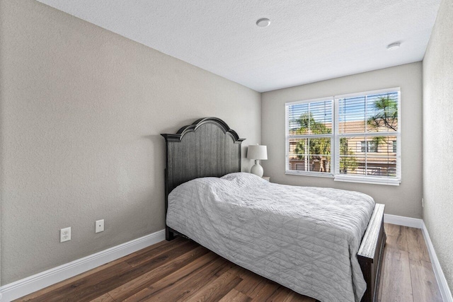 bedroom featuring dark wood-type flooring and a textured ceiling