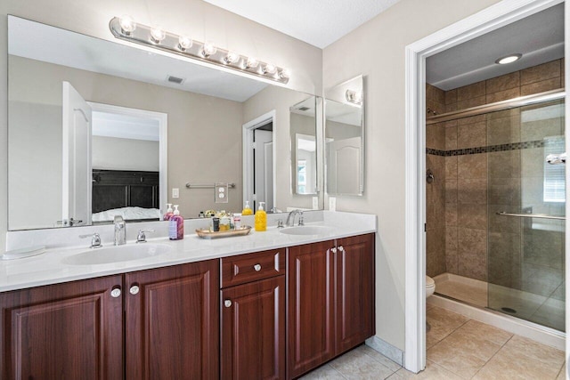 bathroom featuring vanity, tile patterned floors, toilet, and walk in shower