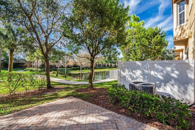 view of patio featuring central AC unit and a water view