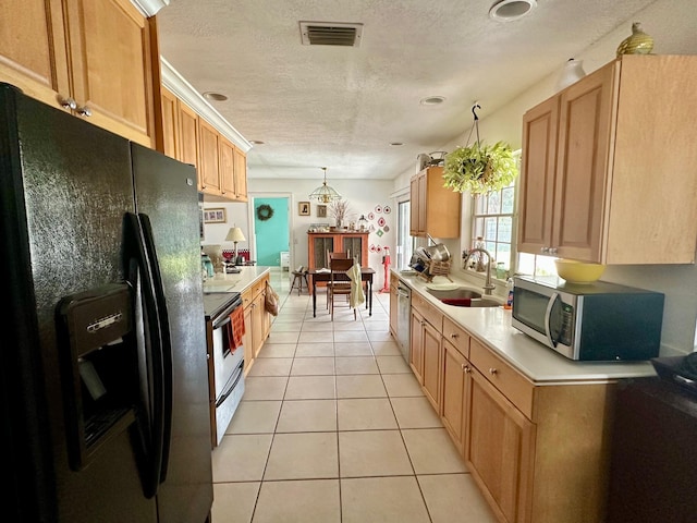 kitchen featuring a sink, visible vents, light countertops, appliances with stainless steel finishes, and decorative light fixtures